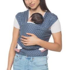 Madre llevando a un bebé de cara a la carretera en un portabebés Aura Wrap Coral Dots 