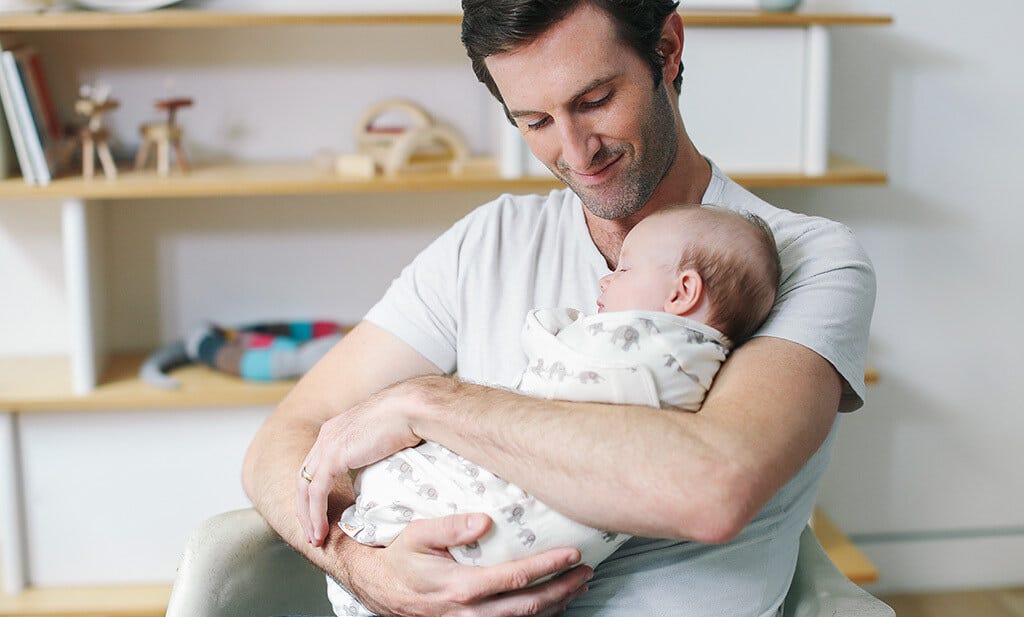 Dad holding Baby in Ergobaby Swaddler